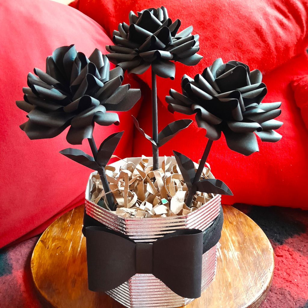 Maceta con tres flores negras de papel